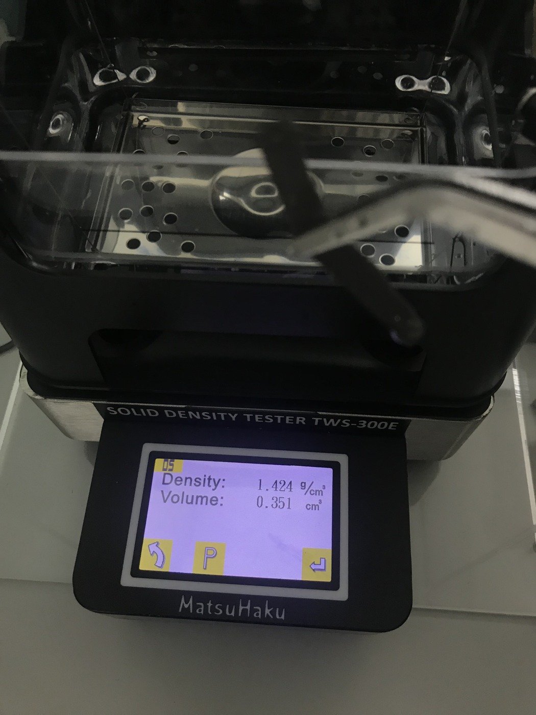 樣本浸入水中吊籃秤重，讀數 1.424 g/cm³。