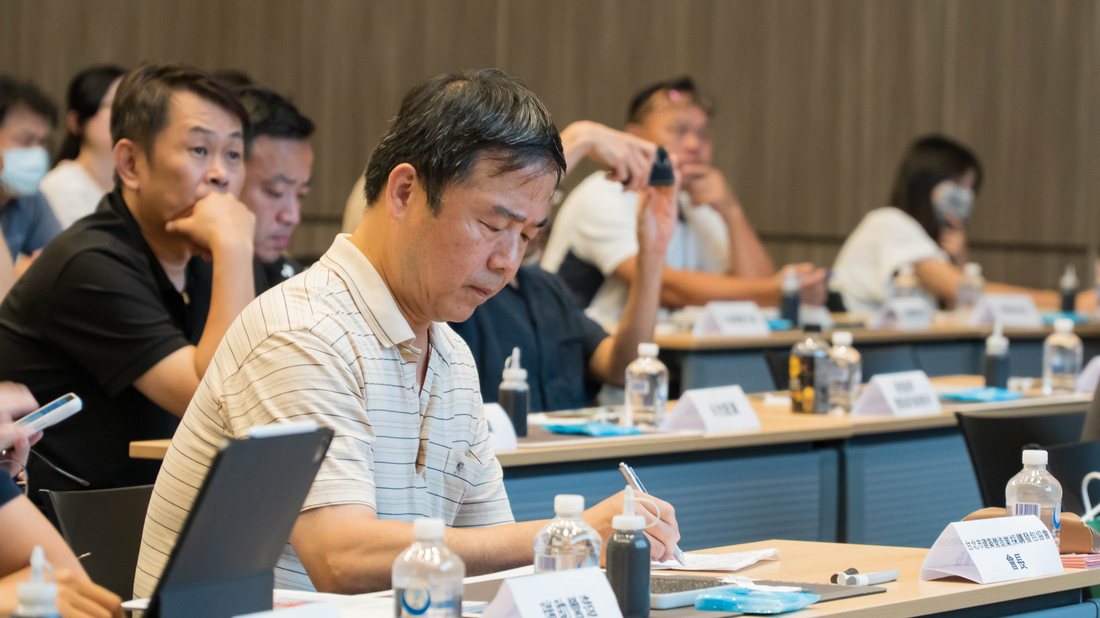 台北市建築暨營造業採購發包協會會長專注聆聽並隨手記錄講座重點
